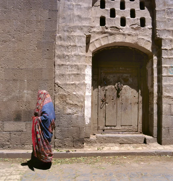 येमेनमधील सनाच्या रस्त्यावर एक विरघळलेली मुस्लिम महिला चालते — स्टॉक फोटो, इमेज