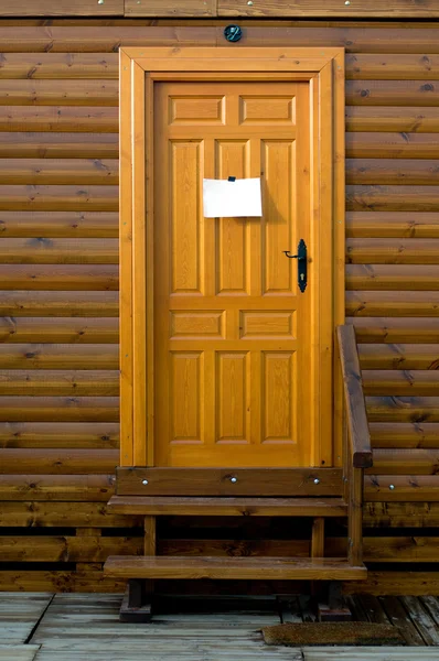 Puerta de madera rústica con un cartel en blanco — Foto de Stock