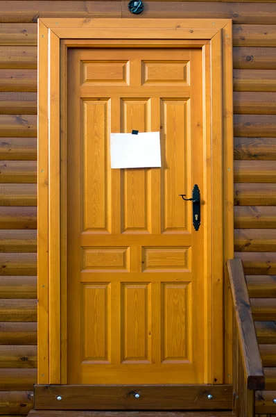 Porta de madeira rústica com um sinal em branco — Fotografia de Stock