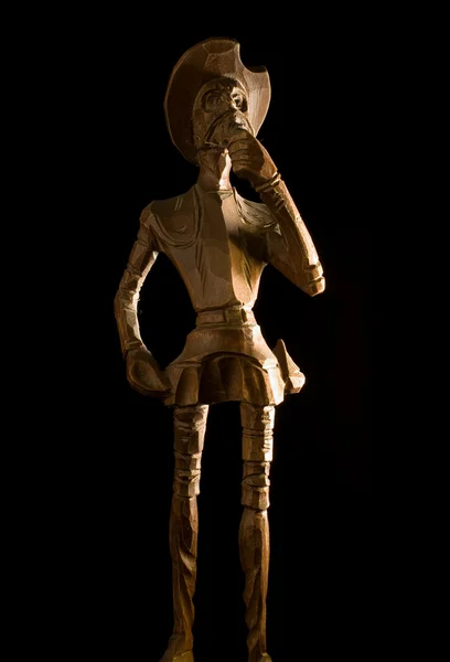 Vecchio cavaliere di legno Don Quijote de la Mancha su sfondo nero . — Foto Stock