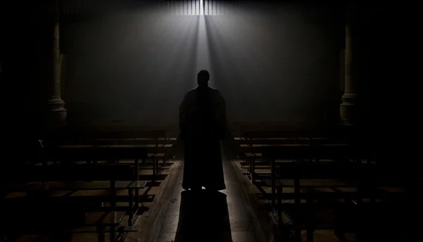 Mönch in einer romanischen Kirche mit einem göttlichen Lichtstrahl. — Stockfoto