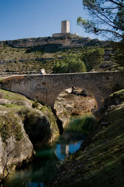 Ponte românica El Picazo e Torre de Campo no horizonte. Alarcon em Cuenca. Spa — Fotografia de Stock