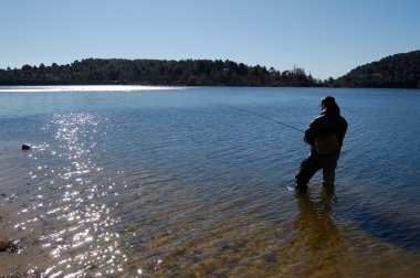 Fisherman fishing on a lake clipart