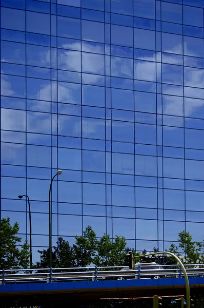 Construção moderna de aço e vidro e nuvens refletidas no edifício de vidro — Fotografia de Stock