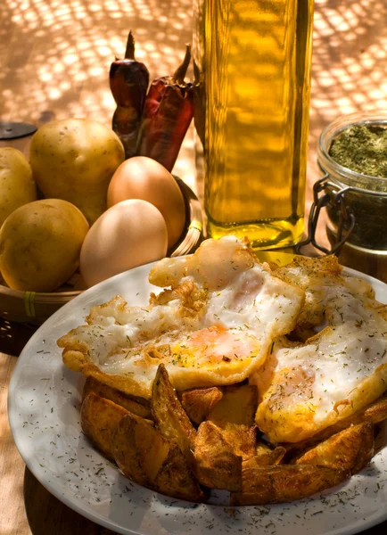 Ovos fritos com batatas servidas em uma placa branca . — Fotografia de Stock