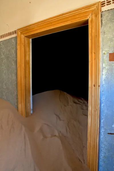 A dune coming from a door in a house at kolmanskop ghost town namibia afric — Stock Photo, Image