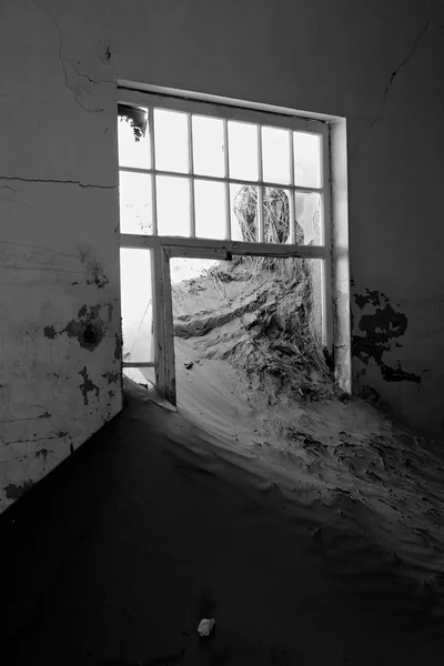 Una duna que viene de una ventana en una casa en kolmanskop fantasma ciudad namibia afr —  Fotos de Stock