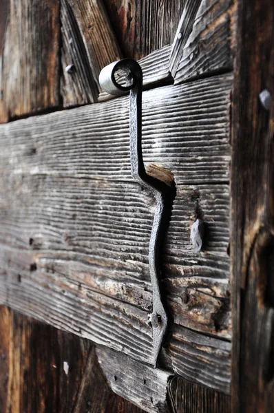 Una manija de puerta muy vieja en una puerta de madera —  Fotos de Stock