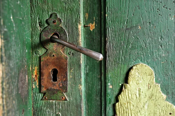 Una manija de puerta muy vieja en una puerta de madera —  Fotos de Stock