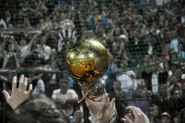 Taça de bola dourada e torcedores de futebol — Fotografia de Stock