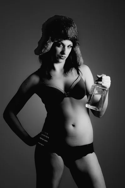 Mulher forte com busby tomando uma garrafa de vodka na mão — Fotografia de Stock