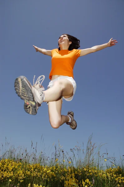 Kaunis nuori nainen hyppää — kuvapankkivalokuva