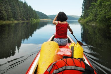 Canoeing girl on a lake clipart