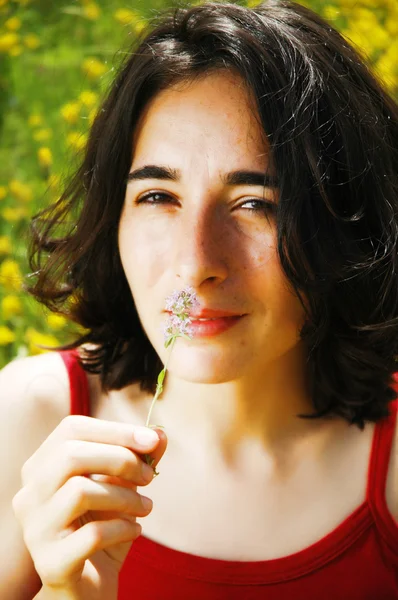Beautiful portrait of a young sexy woman smelling a flower — Stock Photo, Image