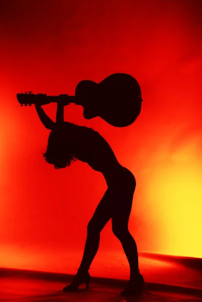 Mujer con silueta de guitarra sobre fondo rojo — Foto de Stock