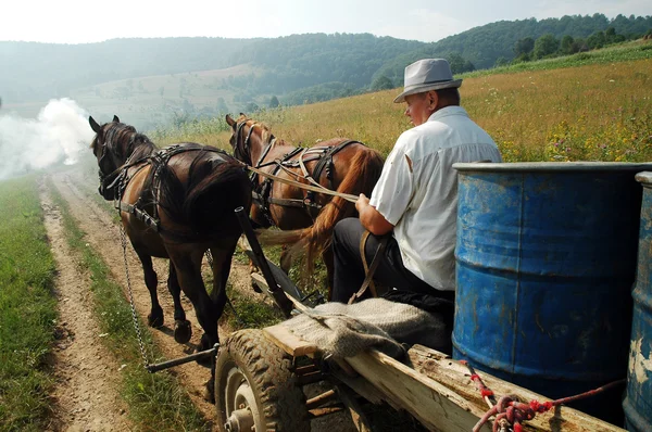 Bauer, der Fässer auf einem Pferdefuhrwerk trägt — Stockfoto