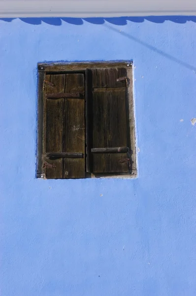 Parede azul com uma janela de madeira — Fotografia de Stock