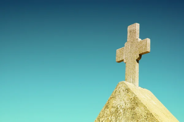 Biały kamień krzyż na niebieskim tle — Zdjęcie stockowe