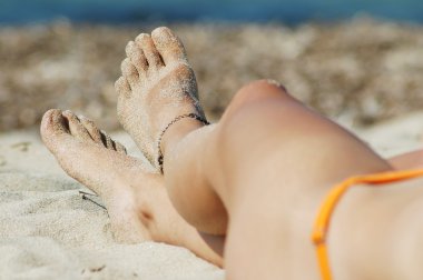 Woman's sexy legs on the beach clipart