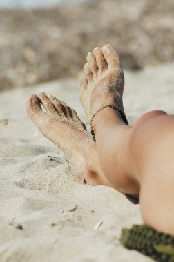 Woman sexy legs on the beach clipart