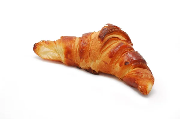 stock image Single fresh croissant, casting soft shadow isolated on white