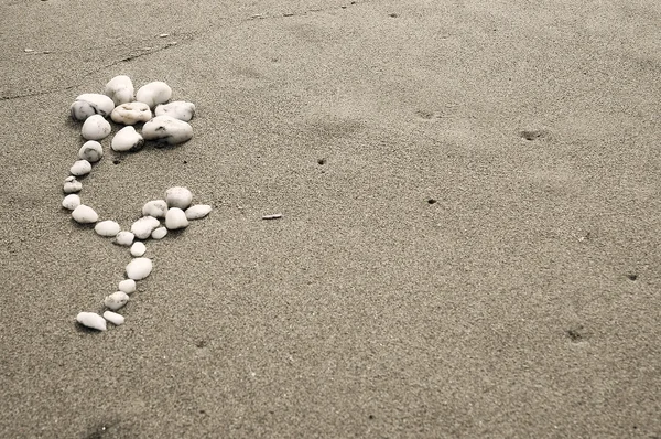 Flor hecha de piedras sobre un fondo de arena —  Fotos de Stock