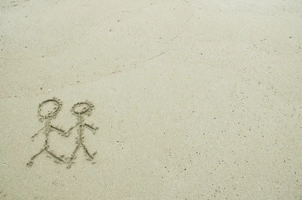 Simple couple drawing in the sand on the beach — Stock Photo, Image