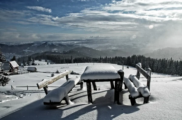 Zasněžené, stůl a lavice v horách — Stock fotografie