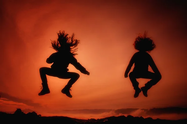 stock image Jumping girls having fun at sunset