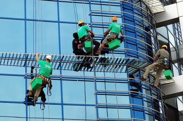 Рабочие моют окна фасада — стоковое фото