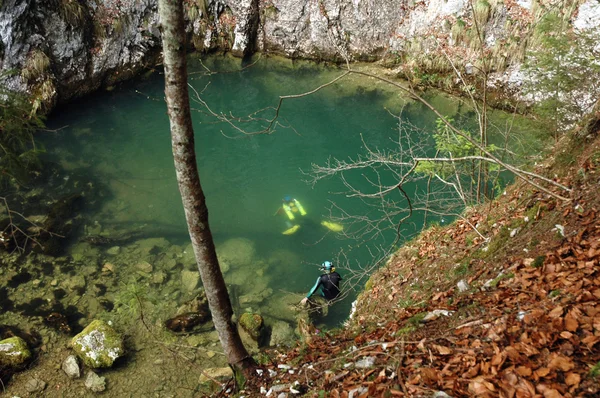 Um mergulhador de caverna emerge de uma fonte — Fotografia de Stock
