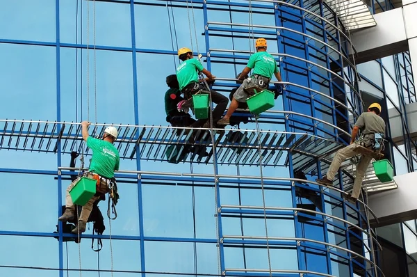 Arbeiter waschen die Fassade der Fenster Stockfoto