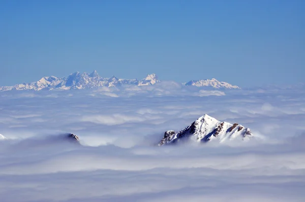 Mraky a mlha nad krásné slunečné Zimní krajina v al — Stock fotografie