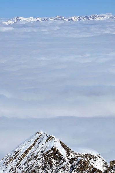 Mraky a mlha nad krásné slunečné Zimní krajina v al — Stock fotografie