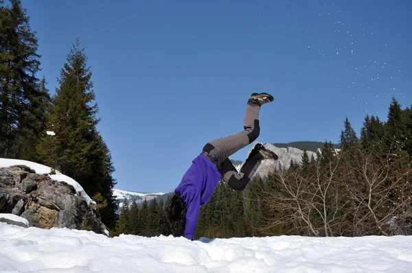 Mujer joven haciendo una voltereta en la nieve —  Fotos de Stock