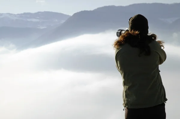 Woman photographing above clouds — Stock Photo, Image