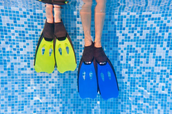 Niños bajo el agua piernas en aletas en la piscina —  Fotos de Stock