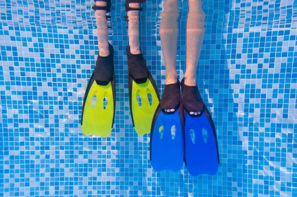 Podvodní děti nohy v ploutvemi v bazénu — Stock fotografie