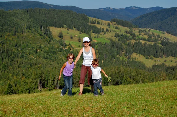 Active mother and children on their vacation in mountains — Stock Photo, Image