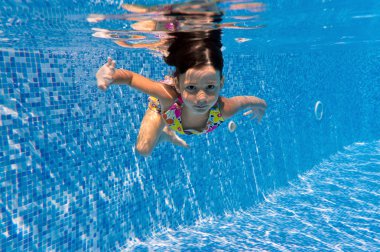 Happy smiling underwater child in swimming pool clipart