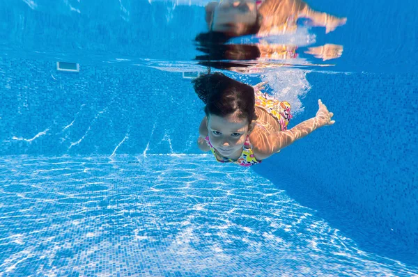 Gelukkig lachend onderwater kind in zwembad — Stockfoto