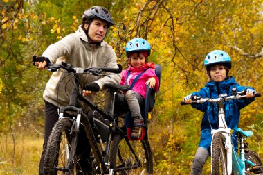 Happy active family cycling on bikes outdoors clipart