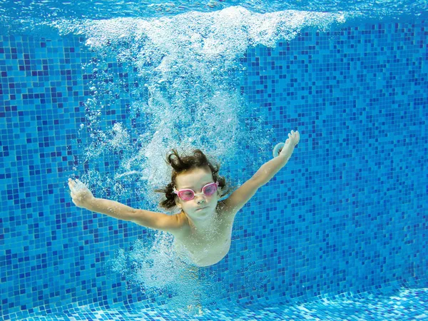 Criança ativa feliz salta para a piscina, vista subaquática — Fotografia de Stock