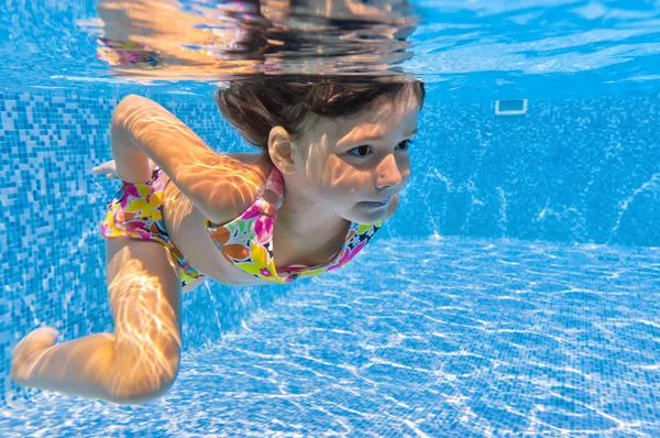 Gelukkig lachend onderwater jong geitje in zwembad — Stockfoto