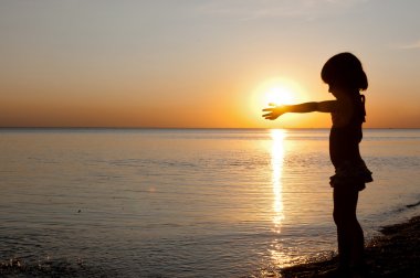 sunset Beach, eğlenceli olan küçük bir kız çocuğu siluet