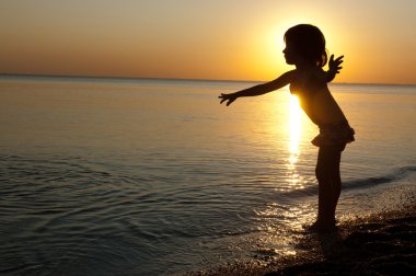 sunset Beach, eğlenceli olan küçük bir kız çocuğu siluet