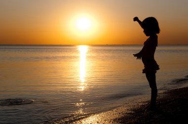 sunset Beach, eğlenceli olan küçük bir kız çocuğu siluet