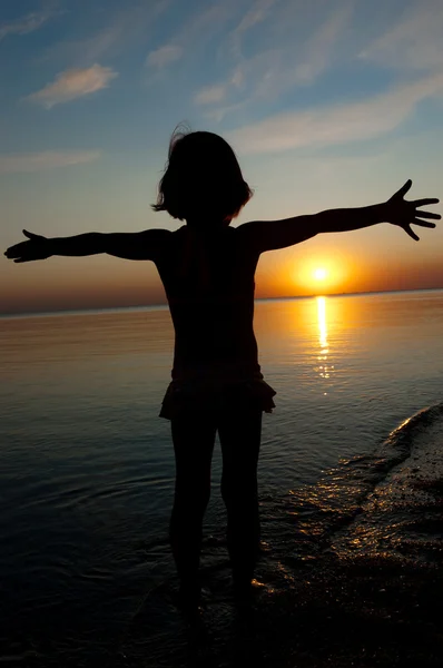 Sylwetka dziecka na zachód słońca plaża, mała dziewczynka zabawy — Zdjęcie stockowe