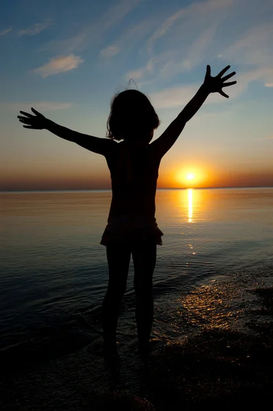 Silhouette bambino sulla spiaggia al tramonto, bambina che si diverte — Foto Stock