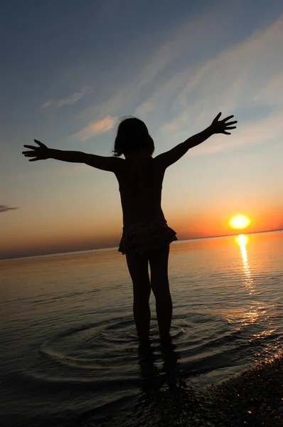 Child silhouette on sunset beach, little girl having fun — Stock Photo, Image